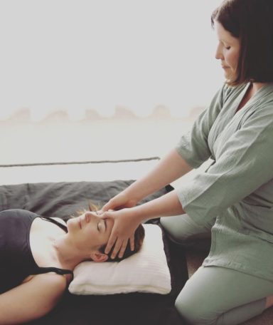 Do-In Femme recevant un massage crânien par une praticienne, dans un cadre apaisant.